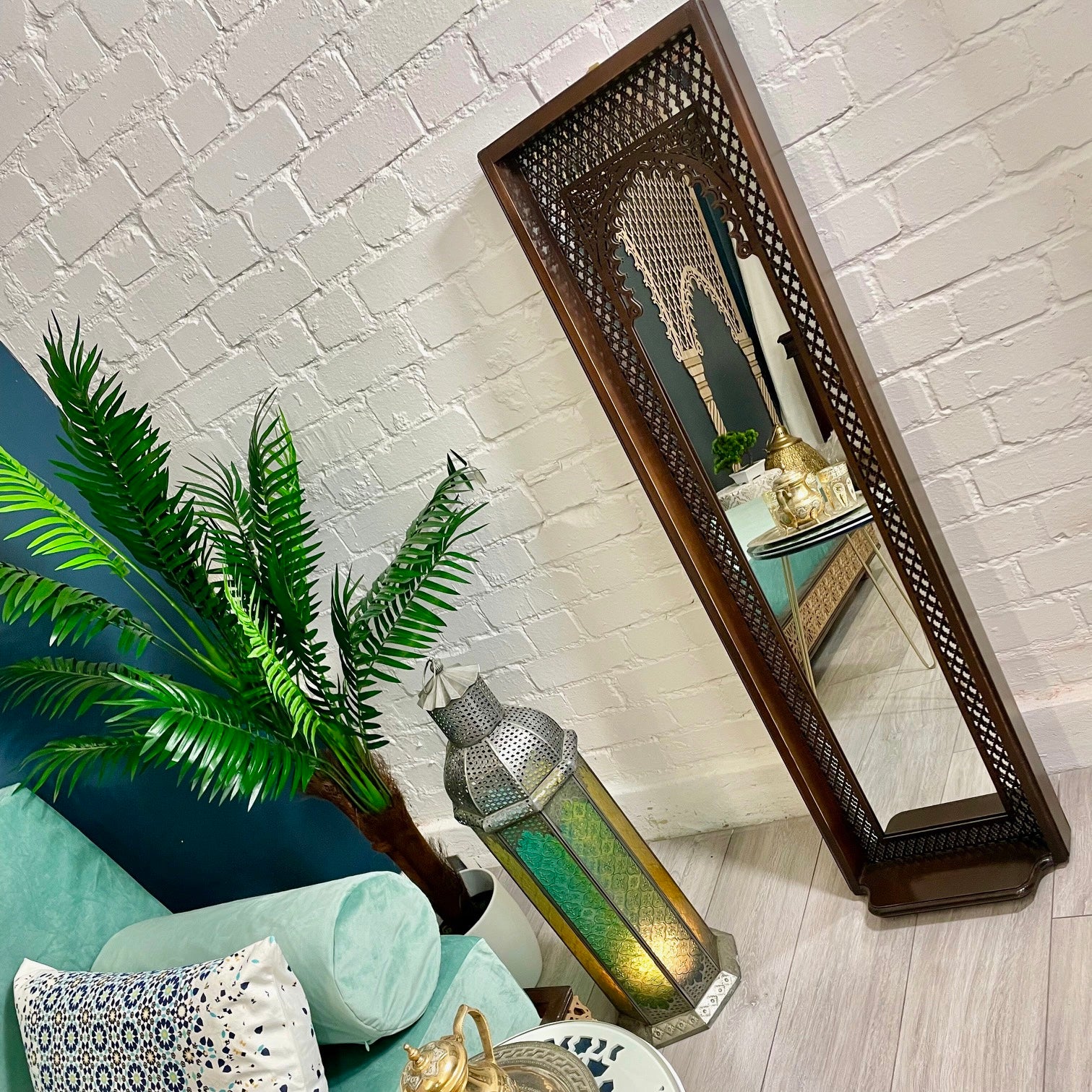 Full length Moroccan mirror in walnut shade standing against a walll